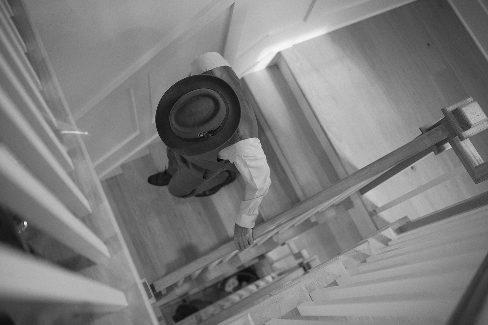 Black and white cinematic style photo of a guest walking down the stairs. 