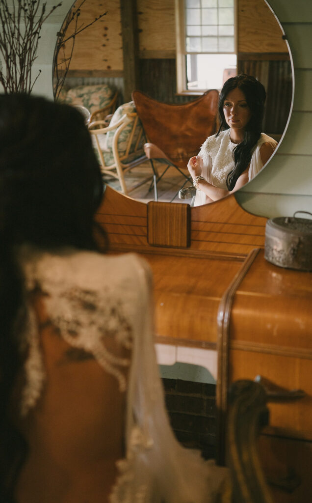 Bride looking at herself in the mirror .
