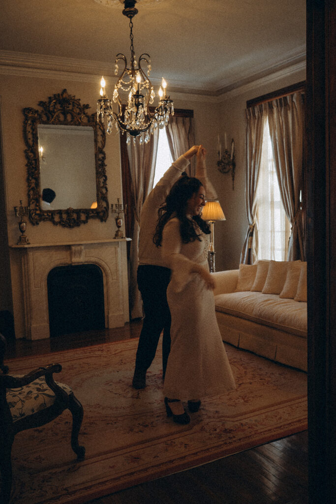 Cinematic style photo of a couple dancing in the living room of a historic home. 