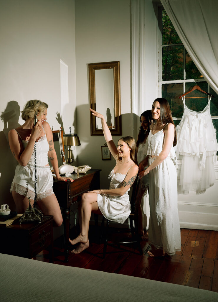 Flash playful photo of a bride and her bridesmaids at Vanity station at Vaux Studio in Philadelphia.