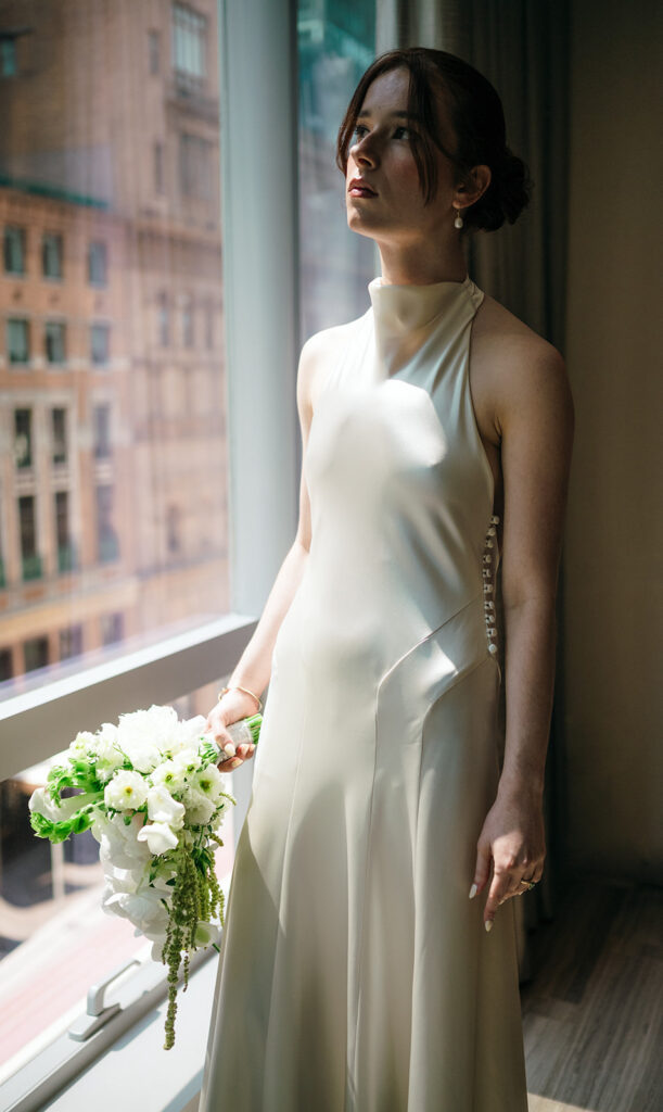 Bride staring out her hotel window in NYC.