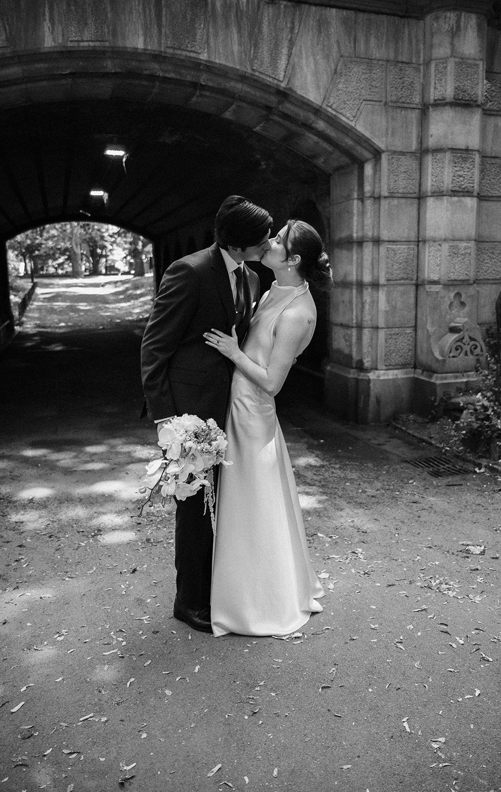 Black and white photo of a couple kissing in Central Park.
