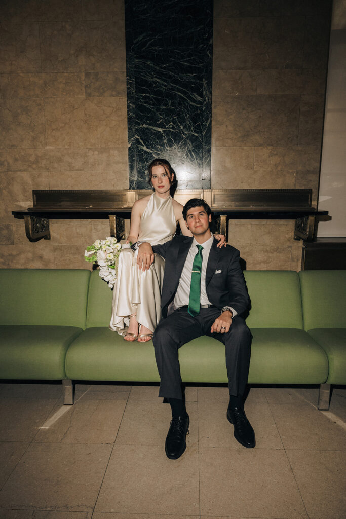 Bride and groom sitting together as they wait for their NYC City Hall elopement ceremony.