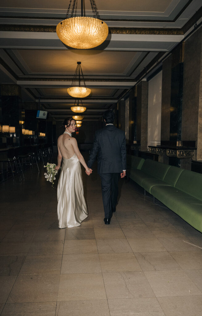 Bride and groom walking down a hallway during their NYC City Hall elopement photos.