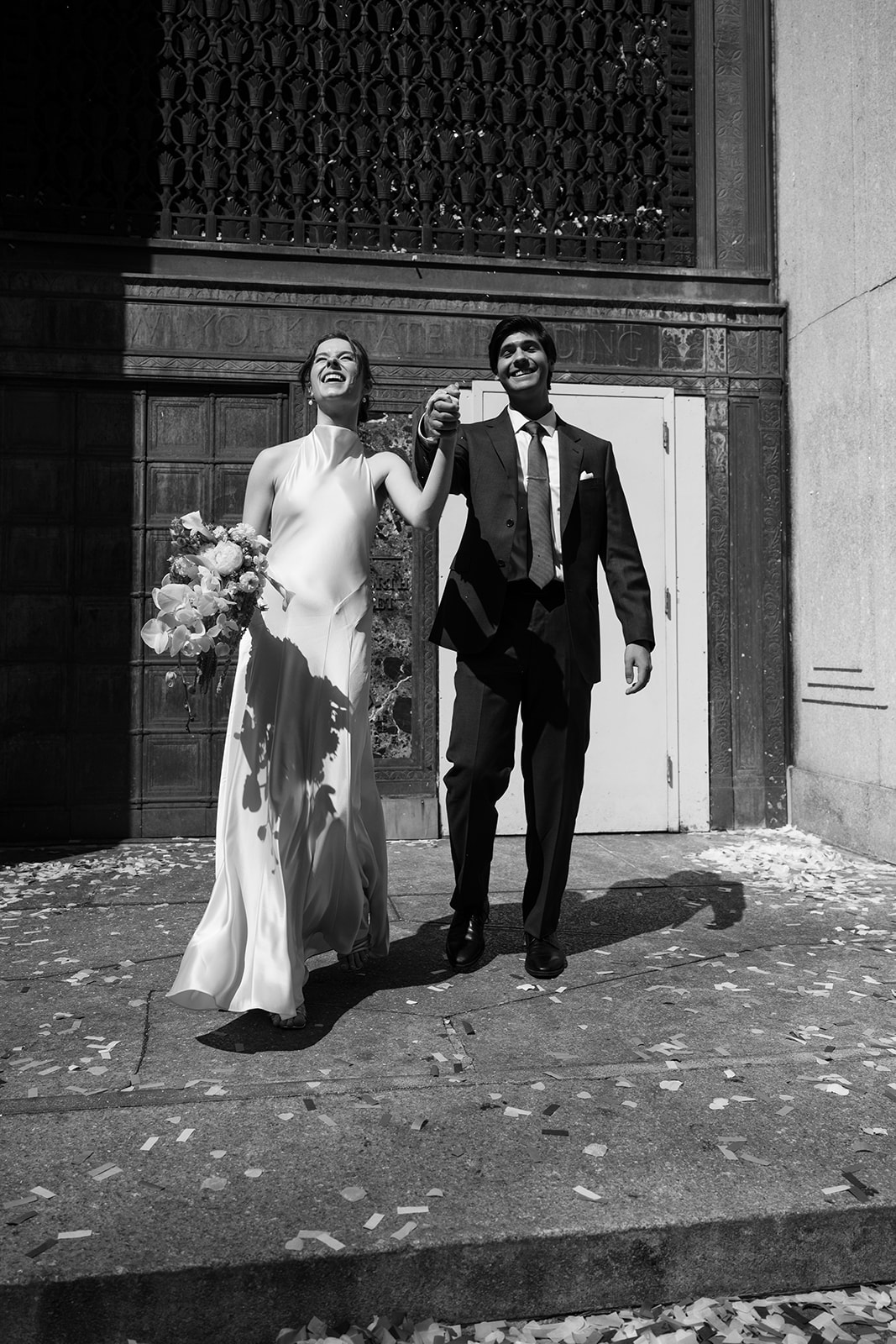 Black and white photo of a couple exiting their NYC City Hall elopement. 