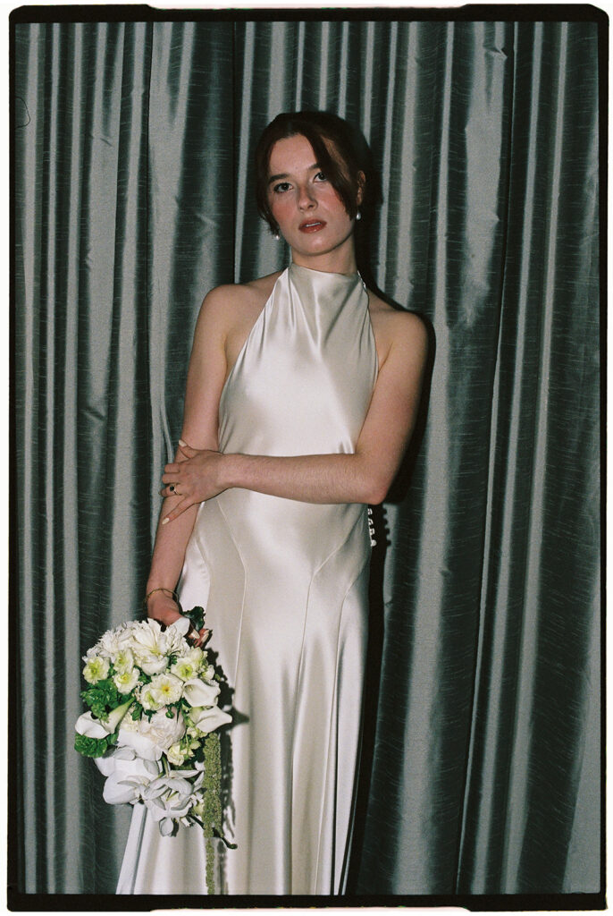 Bride holding a bouquet in her hotel room captured on film.