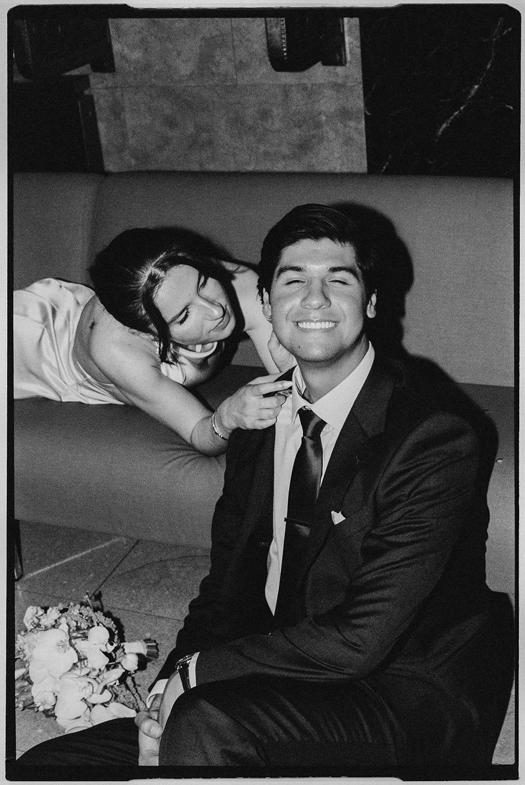 Black and white film photo of a couple waiting in the lobby for their NYC City Hall elopement.