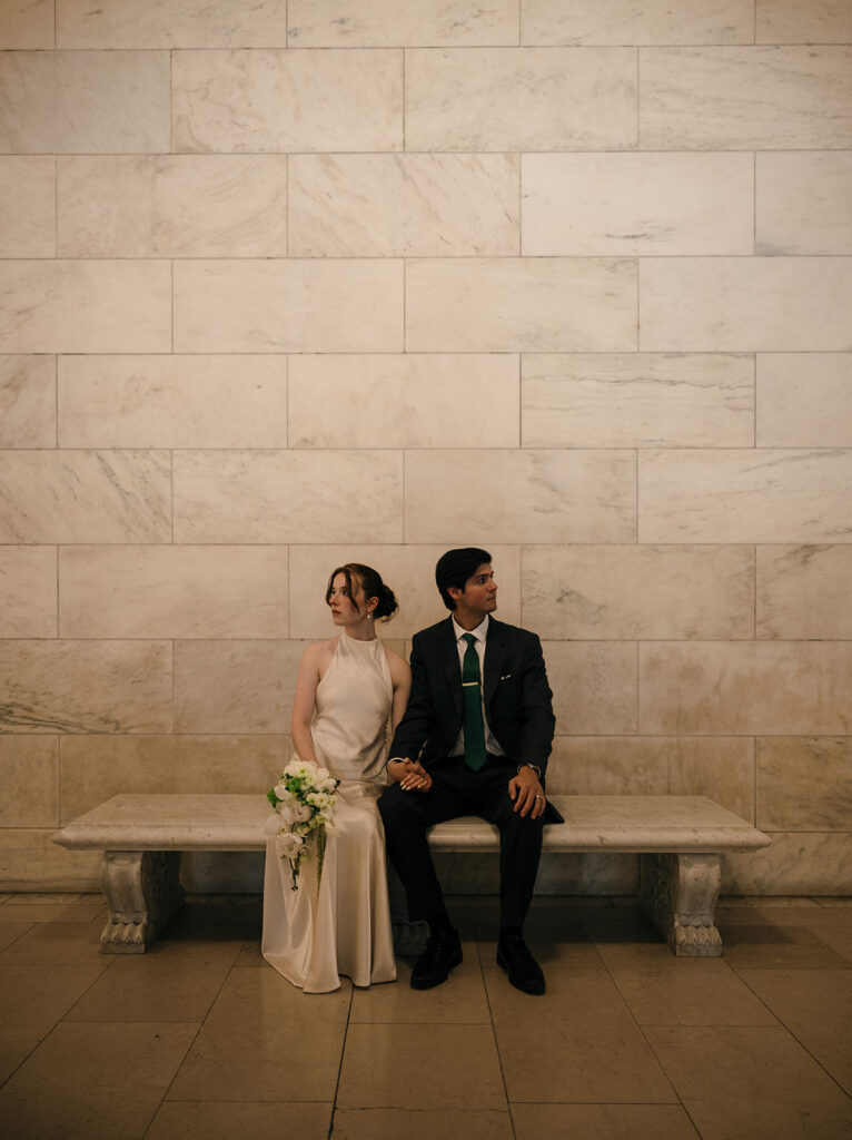Bride and groom sitting on a bench at The New York Public Library.